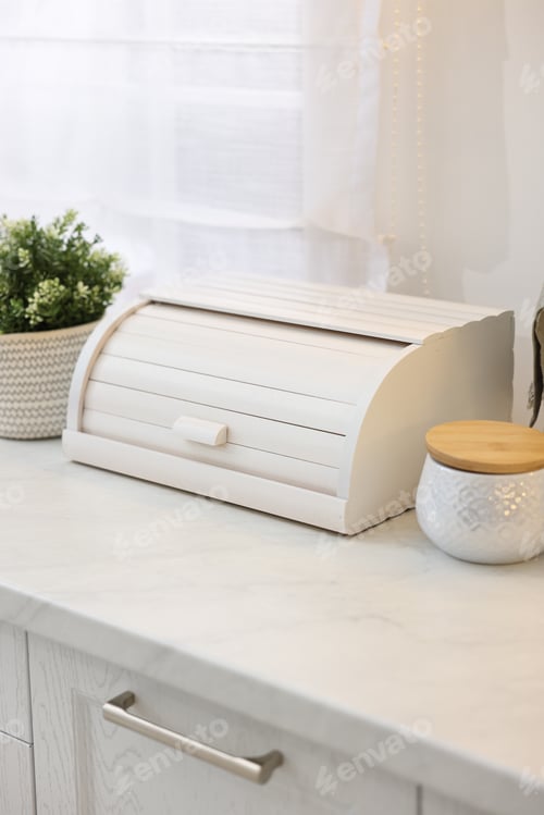 Preview: Wooden bread box and decorative elements on white countertop in kitchen