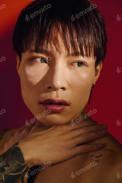Preview: Stylish young man with striking features poses against a vibrant colorful background