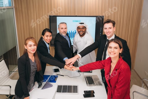 Preview: Businesspeople are laughing and giving each other stack of hands as they to show the success.