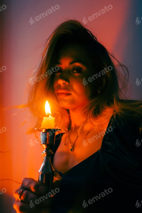 Preview: Portrait of attractive caucasian woman with candlestick in the dark, vintage elegant interior.