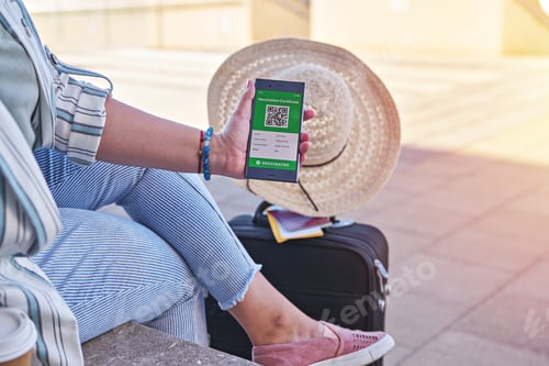 Preview: Vaccinated woman using digital health passport app on smartphone for travel during covid-19 pandemic