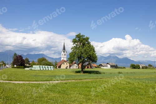 Preview: a beautiful green field with a church and several trees in the background