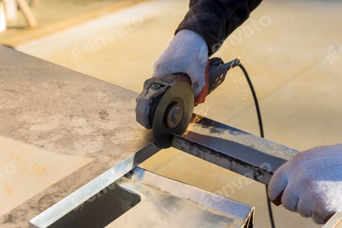 Preview: Metal is being cut by a worker with a grinder as he works