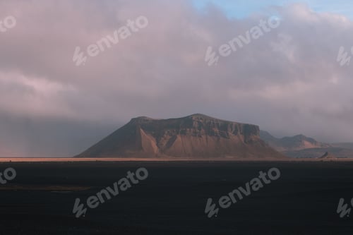 Preview: Scenic view of the majestic Petursey mountain range against a clouded sky in Iceland