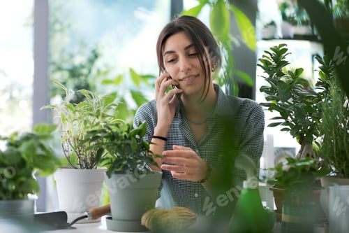 Preview: Woman Gardening Surrounded by Plants Answering Phone