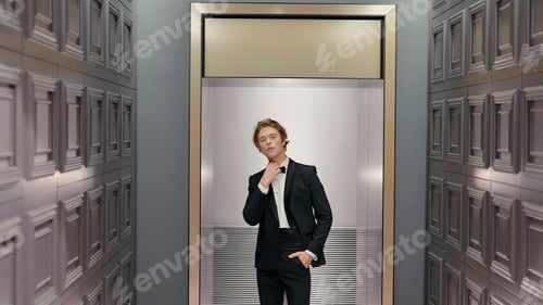Preview: Handsome stylish groom in the hotel interior posing in front of the camera. Action. Man in black
