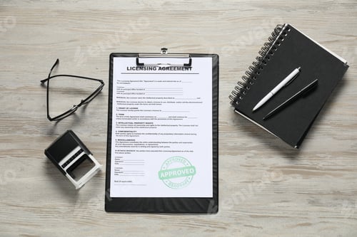 Preview: Licensing agreement document, stationery, glasses and stamp on wooden table, flat lay