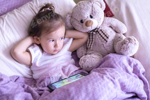 Preview: a little girl of two years falls asleep with a phone in her hands, watching cartoons on a smartphone