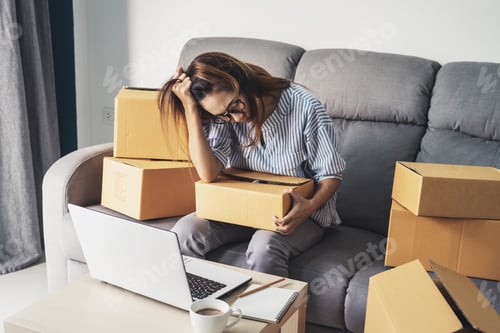 Preview: Stressed and frustrated asian business woman holding head in hands