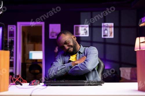 Preview: Gamer wincing while looking at computer monitor after losing videogame
