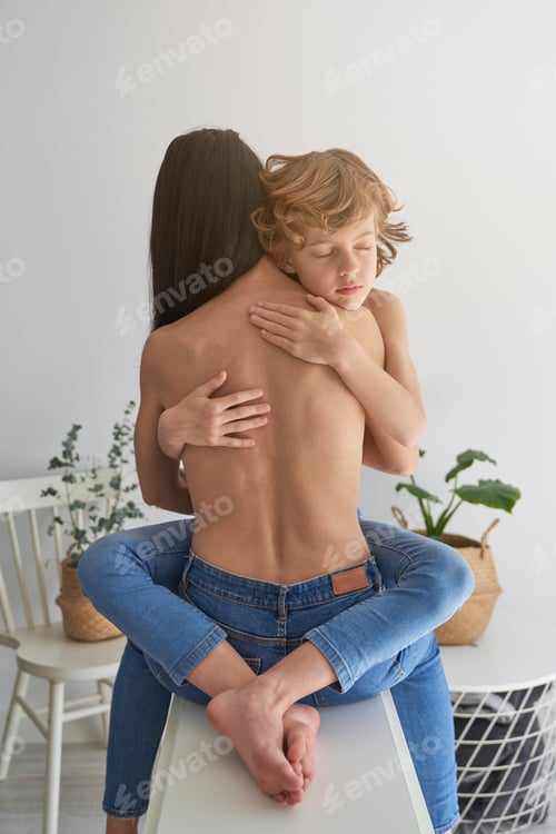 Preview: Faceless topless mother hugging calm boy