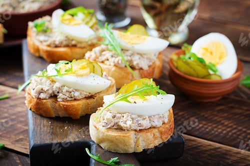 Preview: Toasted bread with a salted codfish mousse on wooden cutting board