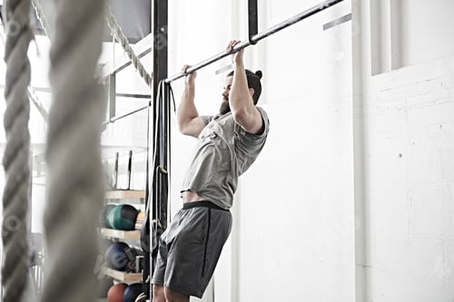 Preview: Man doing chin-up in cross training gym