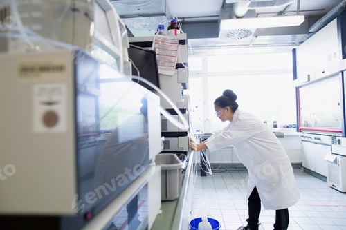 Preview: Young female scientist using scientific equipment in lab