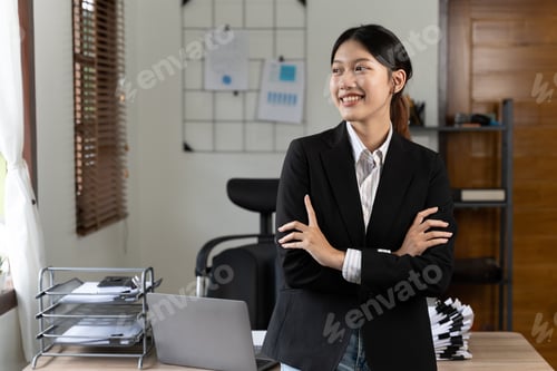 Preview: Beautiful smiling young businesswoman sitting at bright modern work station and typing on laptop