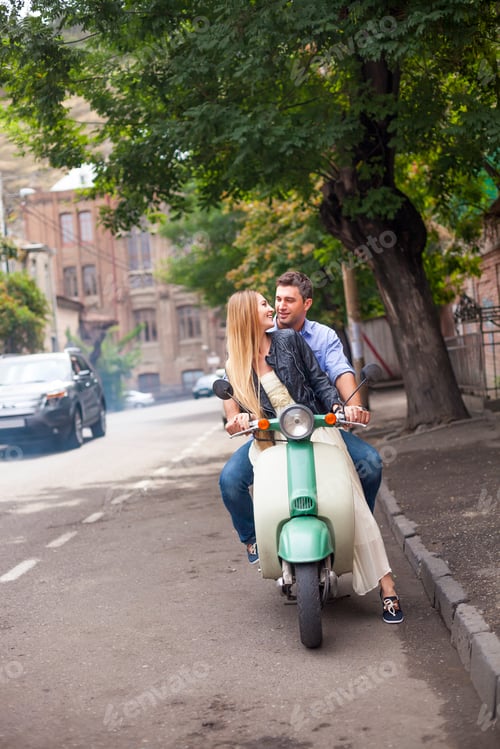 Preview: Happy young couple by a vintage scooter on the street