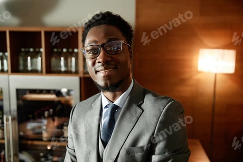 Preview: Smiling young businessman standing in cafe