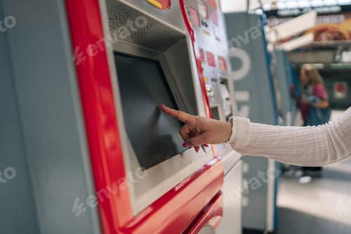Preview: Woman's hand touching the screen of the urban public transport card recharge machine.