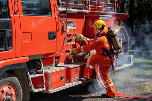 Preview: Firefighter wearing fire protection suite and oxygen tank exercise roll hose connect with fire truck