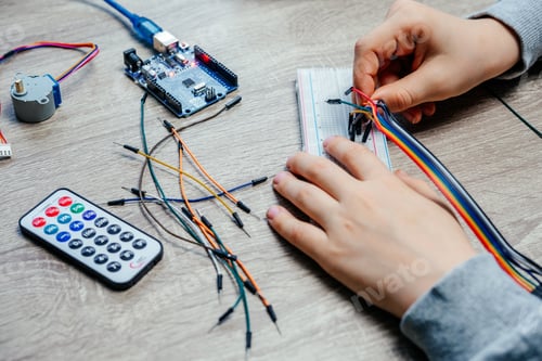 Preview: A child plugging cables to sensor chips while learning arduino coding and robotics