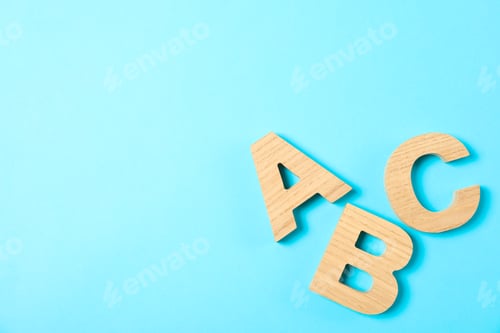 Preview: Wooden letters of English alphabet on color background, space for text