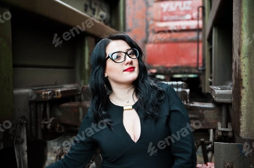 Preview: Brunette girl wear in black with glasses in railway station.