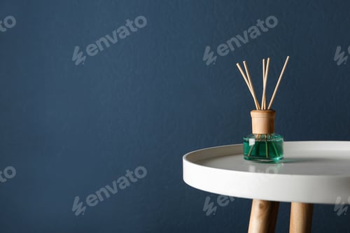 Preview: Reed air freshener on table against dark blue background, space for text