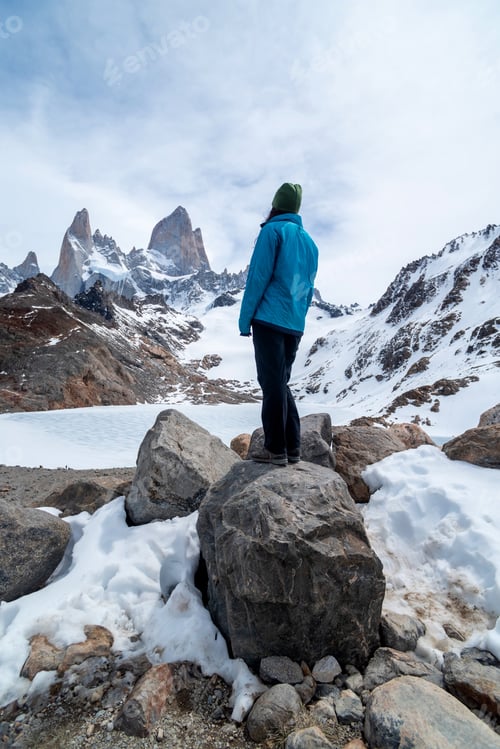 Preview: A hiker woman with a blue jacket on the base of Fitz Roy Mountain in Patagonia, Argentina