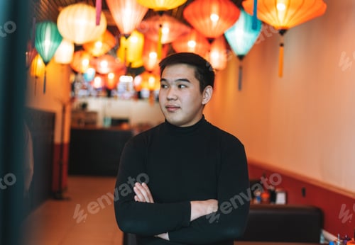 Preview: Handsome young asian man in black clothes in festive chinese vietnamese restaurant