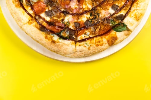 Preview: Delicious large pizza with bacon and spinach on a yellow background