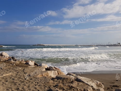 Preview: Ocean Waves Crashing onto Sandy Beach Under Blue Sky