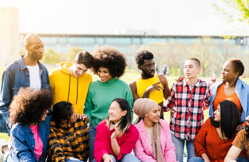 Preview: handsome multiracial friends meeting in the park on their day off at sunset