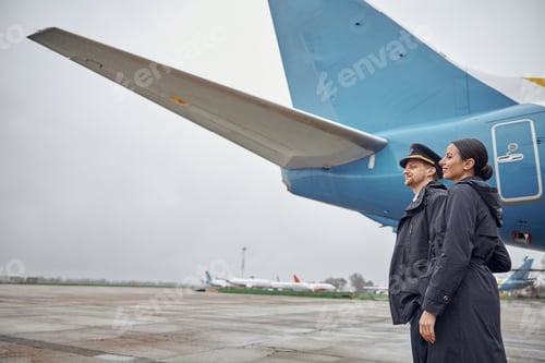 Preview: Portrait of happy confident caucasian airplane crew near plane