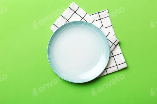 Preview: Top view on colored background empty round blue plate on tablecloth for food. Empty dish