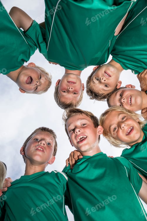 Preview: Happy young football players huddling
