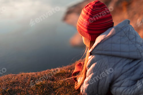 Preview: A girl on the riverbank looks into the distance.