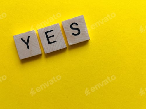 Preview: Yes spelt out in wooden letters on a bright yellow background with copy space