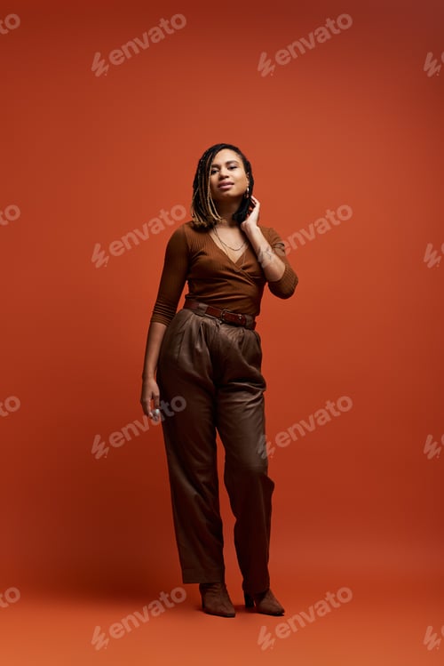 Preview: A stylish young Black woman poses confidently in a colorful studio in the afternoon