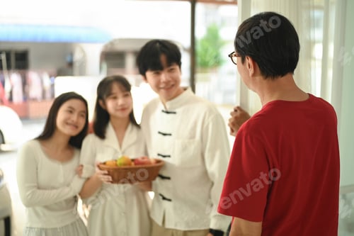 Preview: Cheerful family arriving at a relative home during Chinese New Year.