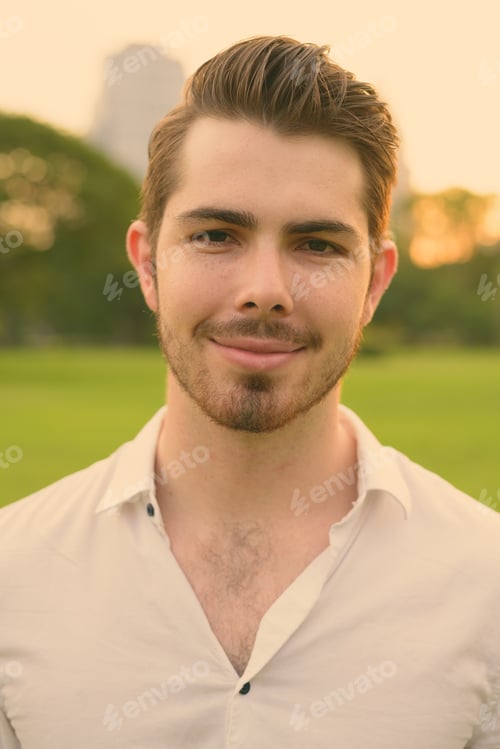Preview: Portrait of young handsome man relaxing at the park
