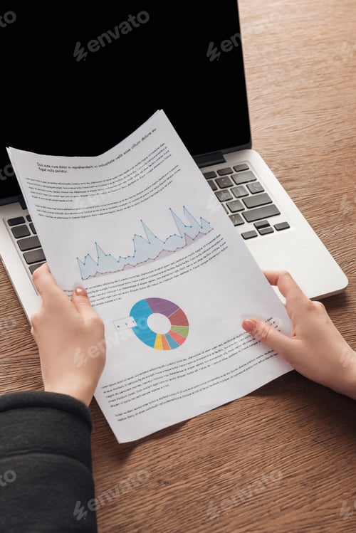 Preview: Cropped view of woman holding documents at workplace