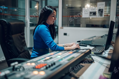 Preview: Middle aged woman using equipment in control room on a tv station