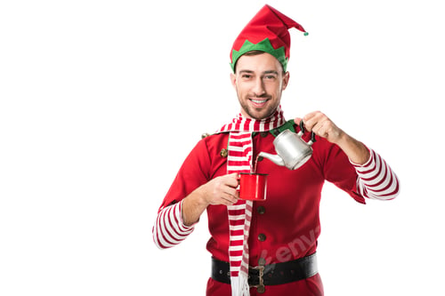 Preview: happy man in christmas elf costume with metal kettle pouring tea in cup and looking at camera