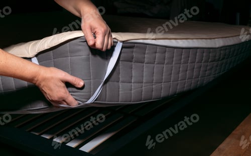 Preview: Woman is putting the bedding cover or mattress pad on the bed or putting off for cleaning process
