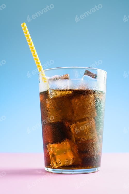 Preview: A glass of cola with ice on blue and pink background