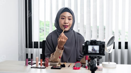 Preview: woman beauty blogger applies lipstick on her mouth and making videos to review cosmetic products