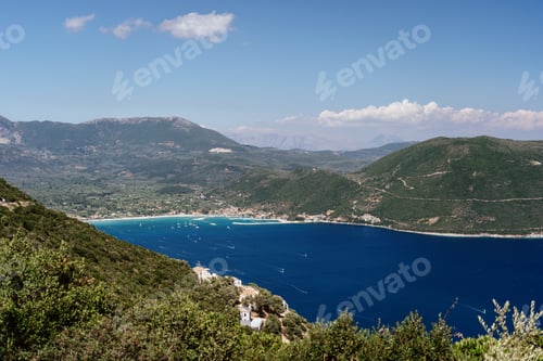 Preview: Scenic coastal landscape with clear blue sea and green hills