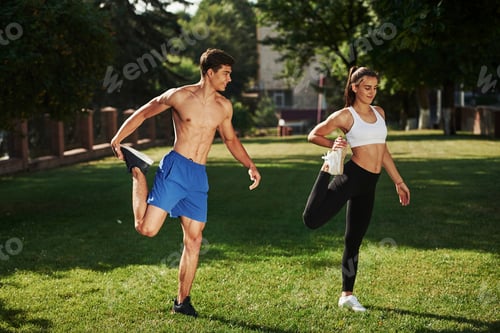 Preview: Guys have nice abs. Man and woman have fitness day in the city at daytime in the park