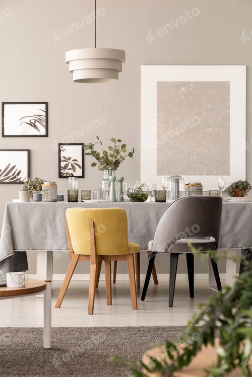 Preview: Grey and yellow chair at table under lamp in dining room interio