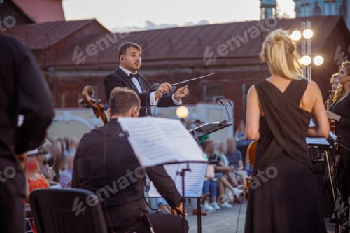 Preview: Conductor directing orchestra performance on the street
